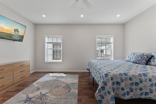 bedroom featuring multiple windows, baseboards, and wood finished floors