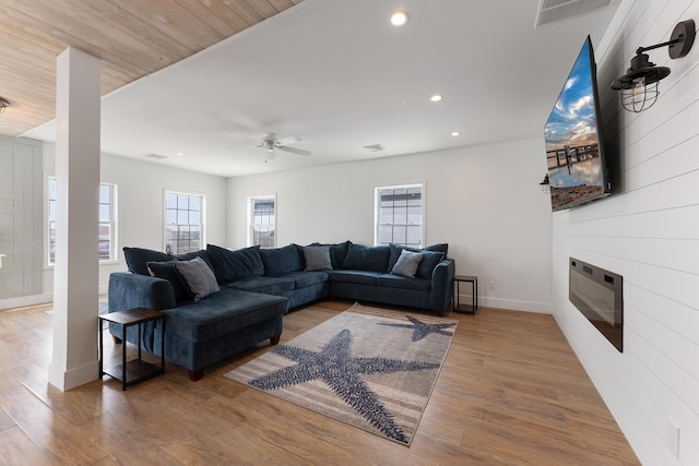 living area with ceiling fan, recessed lighting, a large fireplace, wood finished floors, and visible vents