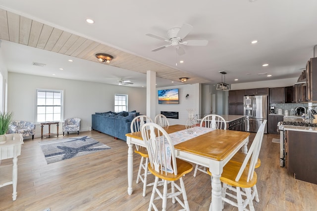 dining room with light wood-type flooring, visible vents, a fireplace, and recessed lighting