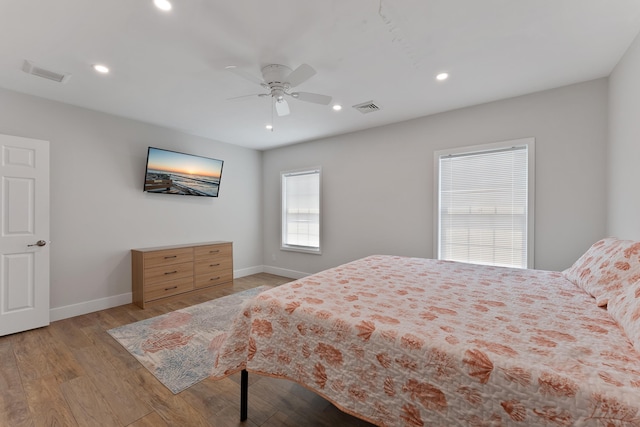 bedroom featuring visible vents, baseboards, and wood finished floors