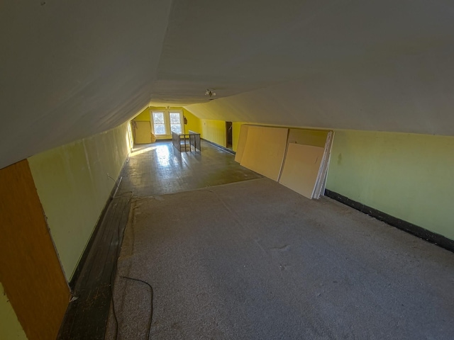 additional living space featuring lofted ceiling and carpet floors