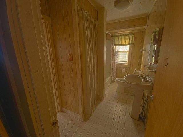 hallway featuring light tile patterned floors and wood walls