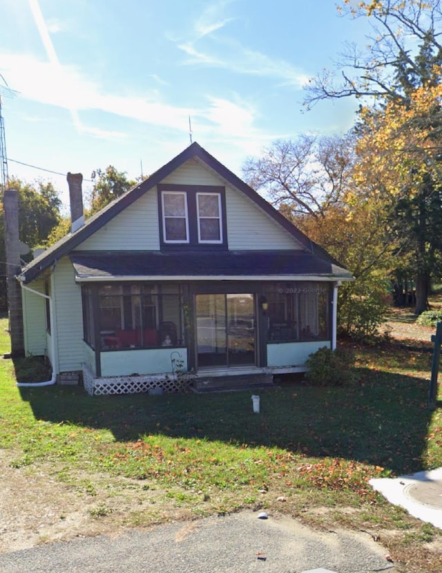 bungalow-style house featuring a front yard and a sunroom