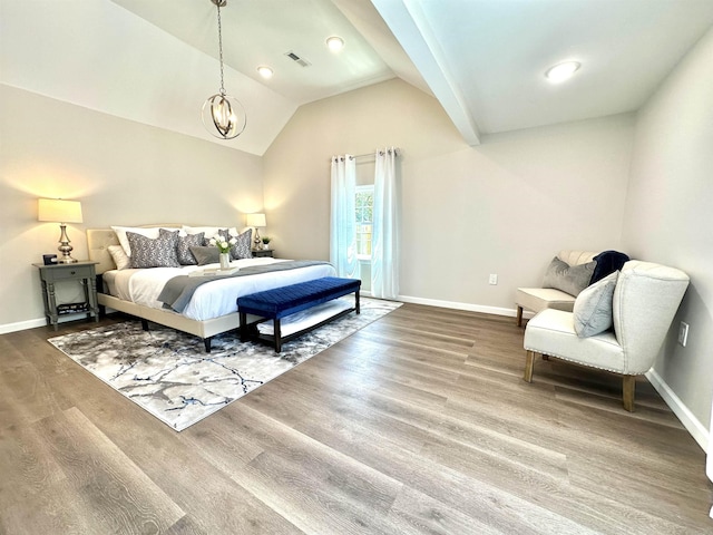 bedroom featuring hardwood / wood-style flooring, a notable chandelier, and vaulted ceiling