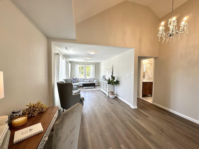 corridor with dark hardwood / wood-style flooring, lofted ceiling, and an inviting chandelier