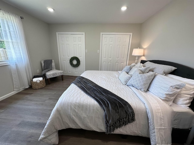 bedroom featuring multiple closets and dark hardwood / wood-style flooring