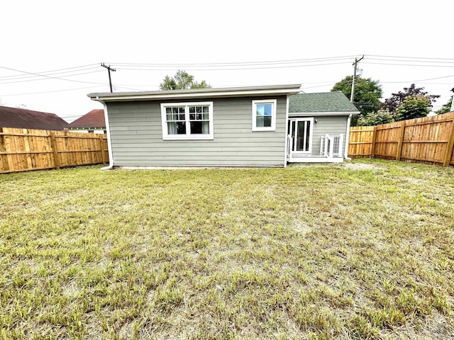 rear view of house featuring a lawn