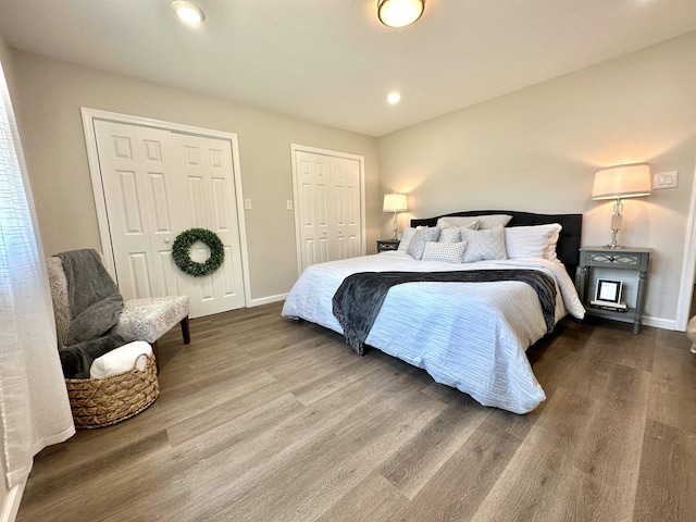 bedroom featuring two closets and hardwood / wood-style flooring