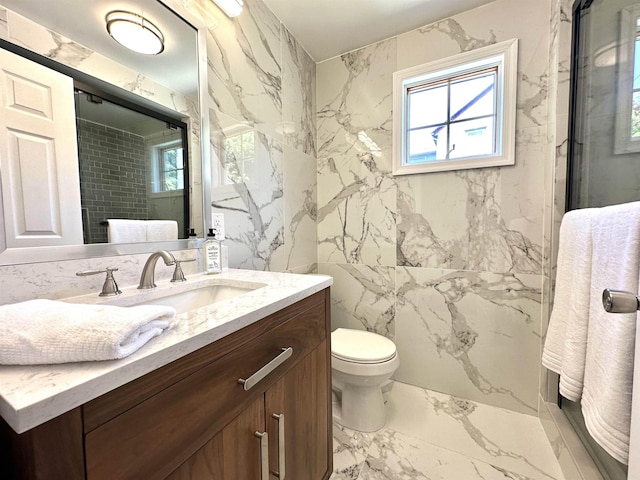 bathroom with vanity, a healthy amount of sunlight, toilet, and a shower with shower door