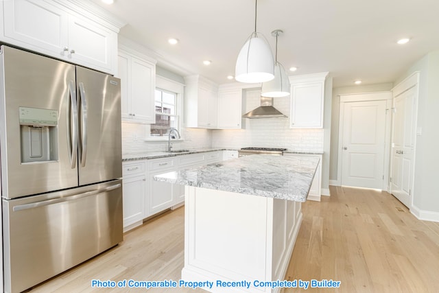 kitchen with white cabinets, light wood-style flooring, stainless steel refrigerator with ice dispenser, and a sink