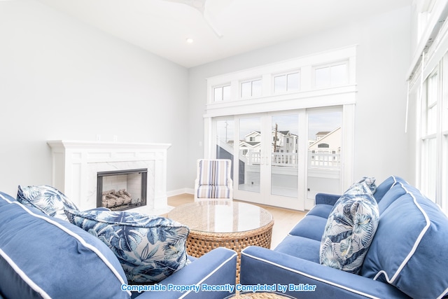 living room with a fireplace, light wood-style flooring, and baseboards