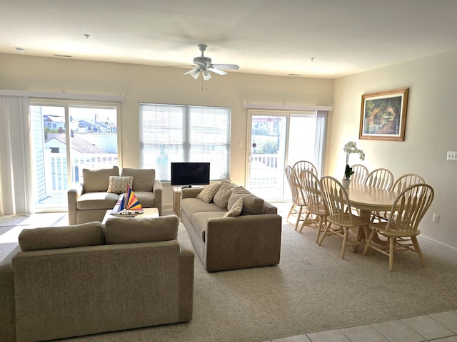 living room with light carpet, ceiling fan, and a healthy amount of sunlight