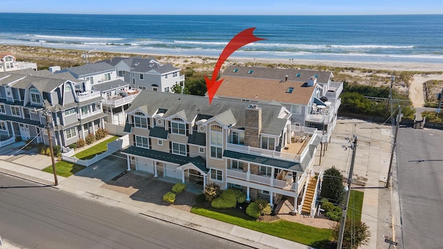 birds eye view of property featuring a beach view and a water view