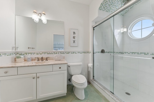 bathroom featuring toilet, tile patterned flooring, an enclosed shower, and vanity