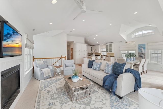 carpeted living room featuring ceiling fan and vaulted ceiling