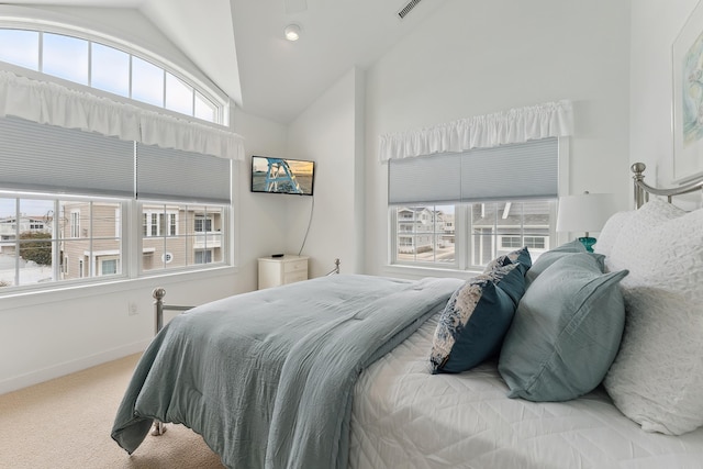 bedroom with carpet floors, multiple windows, and vaulted ceiling