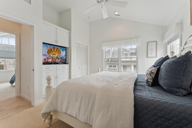 bedroom featuring light carpet, multiple windows, lofted ceiling, and ceiling fan