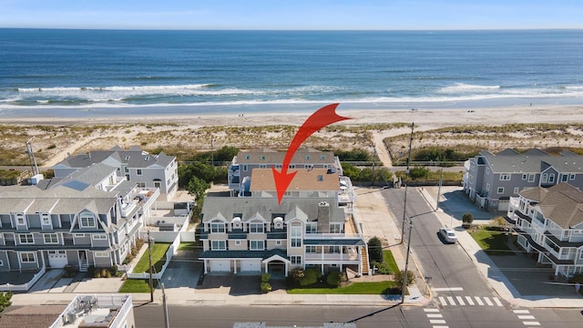 drone / aerial view featuring a water view and a view of the beach