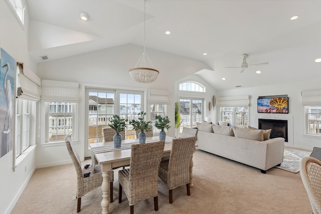 carpeted dining area featuring high vaulted ceiling and ceiling fan