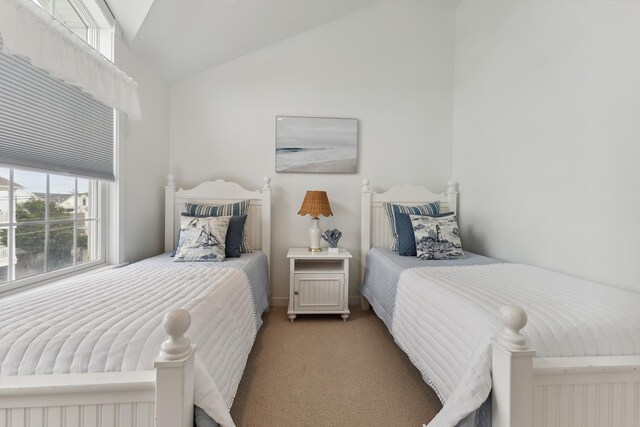 bedroom with light carpet, multiple windows, and lofted ceiling