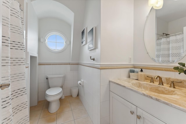 bathroom with radiator heating unit, tile patterned floors, vanity, tile walls, and toilet