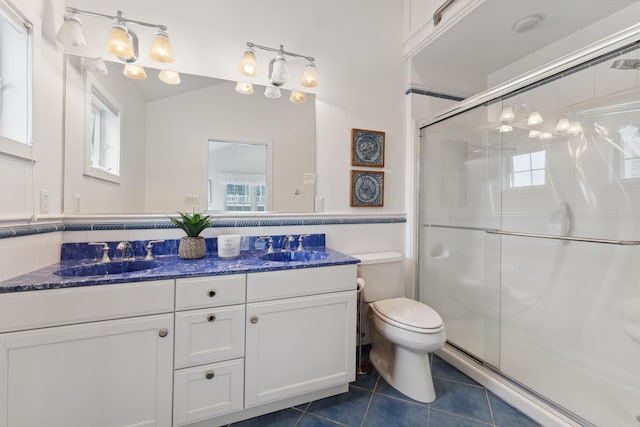 bathroom featuring toilet, tile patterned floors, plenty of natural light, and a shower with door