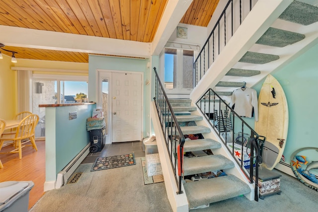 foyer entrance with beamed ceiling, a baseboard heating unit, and wood ceiling