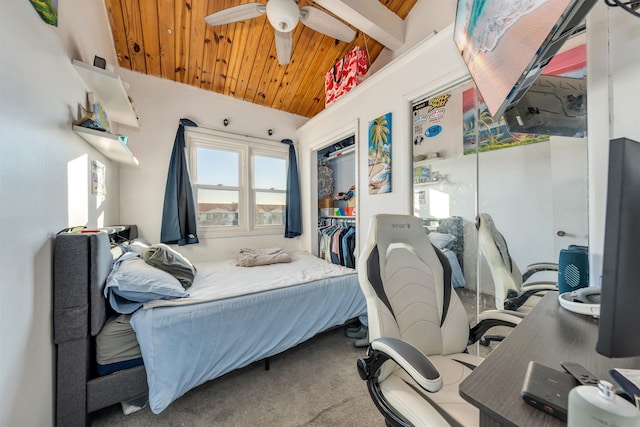 carpeted bedroom with lofted ceiling with beams, wooden ceiling, ceiling fan, and a closet