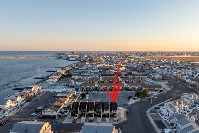 aerial view at dusk featuring a water view