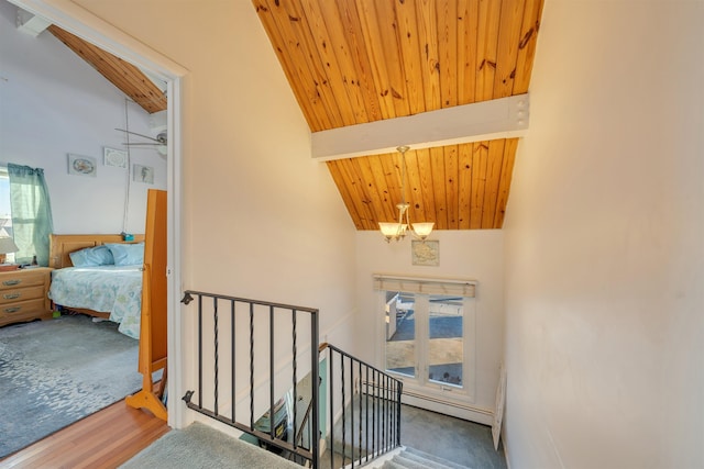 stairs with high vaulted ceiling, beamed ceiling, wood-type flooring, baseboard heating, and wooden ceiling