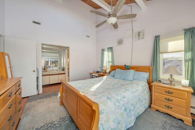 bedroom with multiple windows, connected bathroom, beam ceiling, and ceiling fan