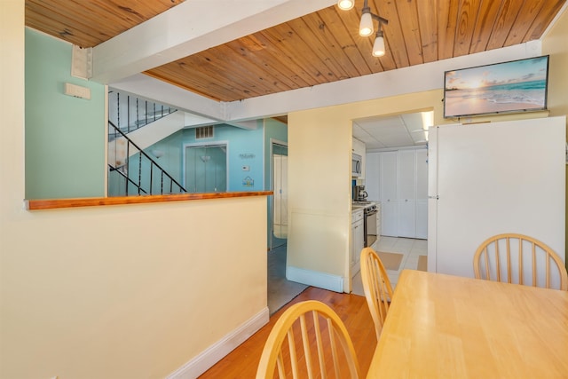 dining room featuring beam ceiling, wooden ceiling, and light hardwood / wood-style floors