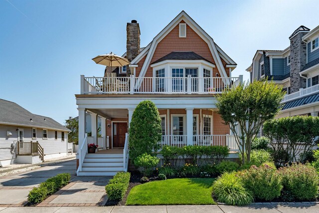 56 E 22nd St, Avalon, NJ 08202 - view of front of home with covered porch, a chimney, and a gambrel roof