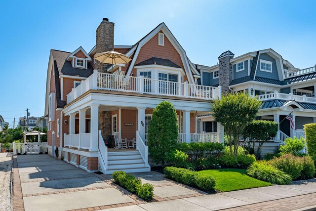 56 E 22nd St, Avalon, NJ 08202 - view of front facade with a gambrel roof, a porch, and a chimney