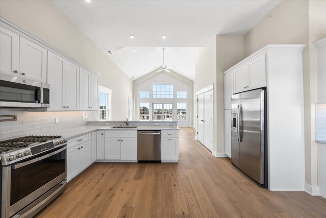310 42nd Pl Unit 201E, Sea Isle City, NJ 08243 - kitchen featuring a peninsula, ceiling fan, white cabinets, a sink, and stainless steel appliances