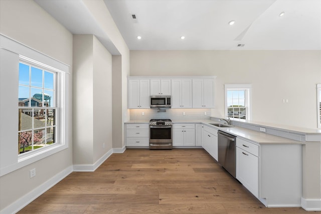 310 42nd Pl Unit 201E, Sea Isle City, NJ 08243 - kitchen with appliances with stainless steel finishes, a sink, light countertops, white cabinets, and a peninsula