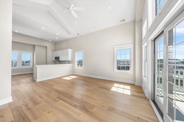 310 42nd Pl Unit 201E, Sea Isle City, NJ 08243 - unfurnished living room with visible vents, baseboards, high vaulted ceiling, a ceiling fan, and light wood-style flooring