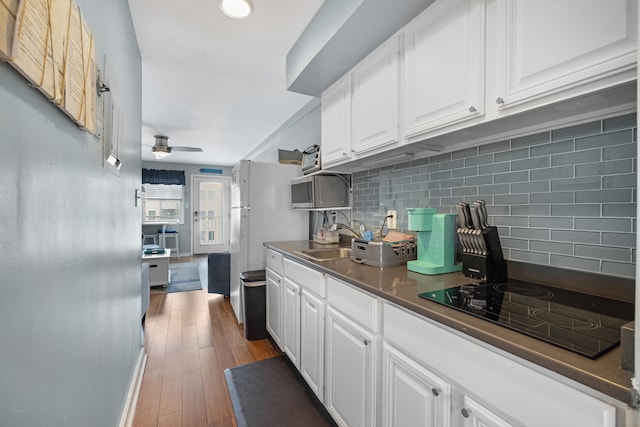 8401 Atlantic Ave # 405, Wildwood Crest, NJ 08260 - kitchen with black electric stovetop, tasteful backsplash, white cabinetry, and dark countertops