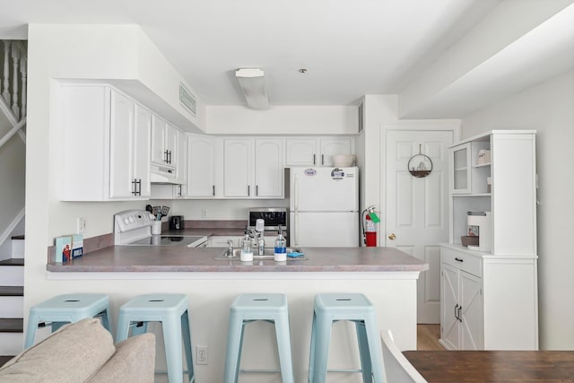 316 E 17th Ave Unit 6, North Wildwood, NJ 08260 - kitchen featuring range, freestanding refrigerator, a peninsula, and a breakfast bar