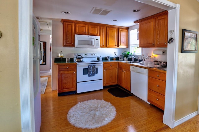 14 Lyndhurst Rd, Marmora, NJ 08223 - kitchen featuring white appliances, light wood-style floors, brown cabinetry, a sink, and dark countertops