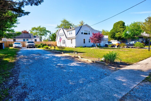 14 Lyndhurst Rd, Marmora, NJ 08223 - view of front facade with a gambrel roof, gravel driveway, and a chimney