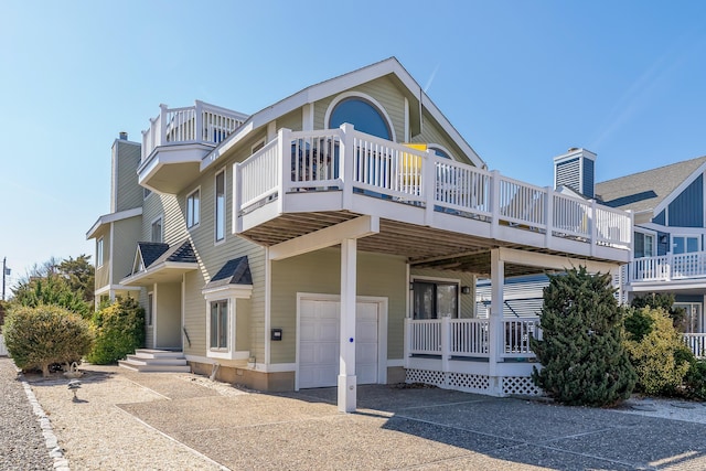 138 8th St, Avalon, NJ 08202 - rear view of property featuring a garage, a chimney, and concrete driveway