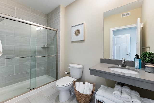 bathroom with toilet, tile patterned floors, an enclosed shower, and sink