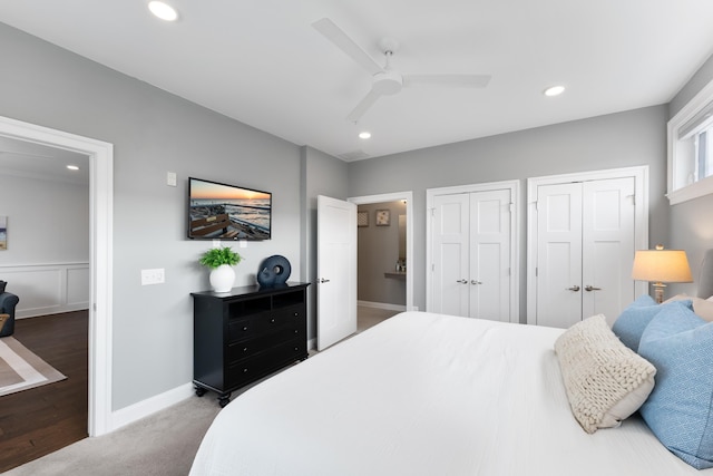 bedroom featuring carpet flooring, ceiling fan, and two closets