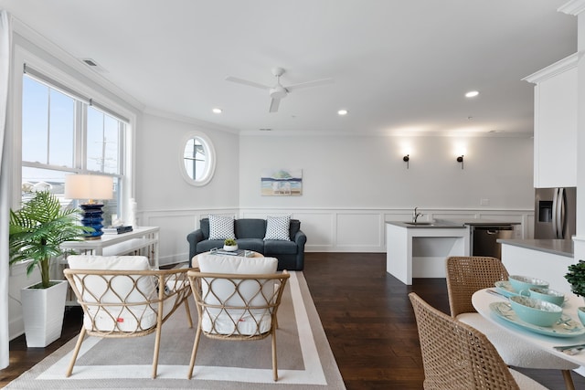 living room featuring dark hardwood / wood-style floors, ceiling fan, and crown molding