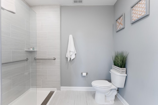 bathroom with tiled shower and toilet