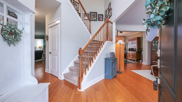 entrance foyer with crown molding and wood-type flooring