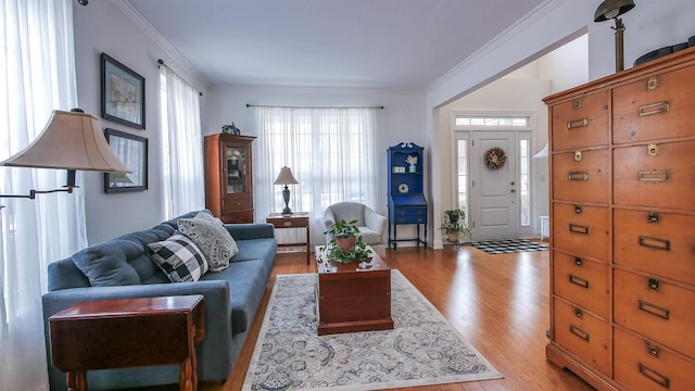 living room with ornamental molding and light hardwood / wood-style floors