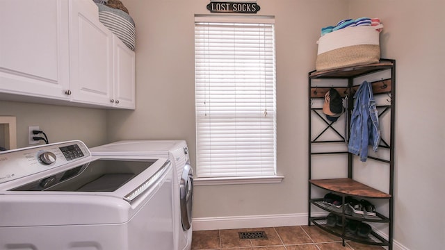 laundry room featuring cabinets, washer and clothes dryer, and dark tile patterned floors