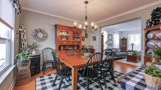 dining room featuring light hardwood / wood-style flooring, ornamental molding, and a notable chandelier